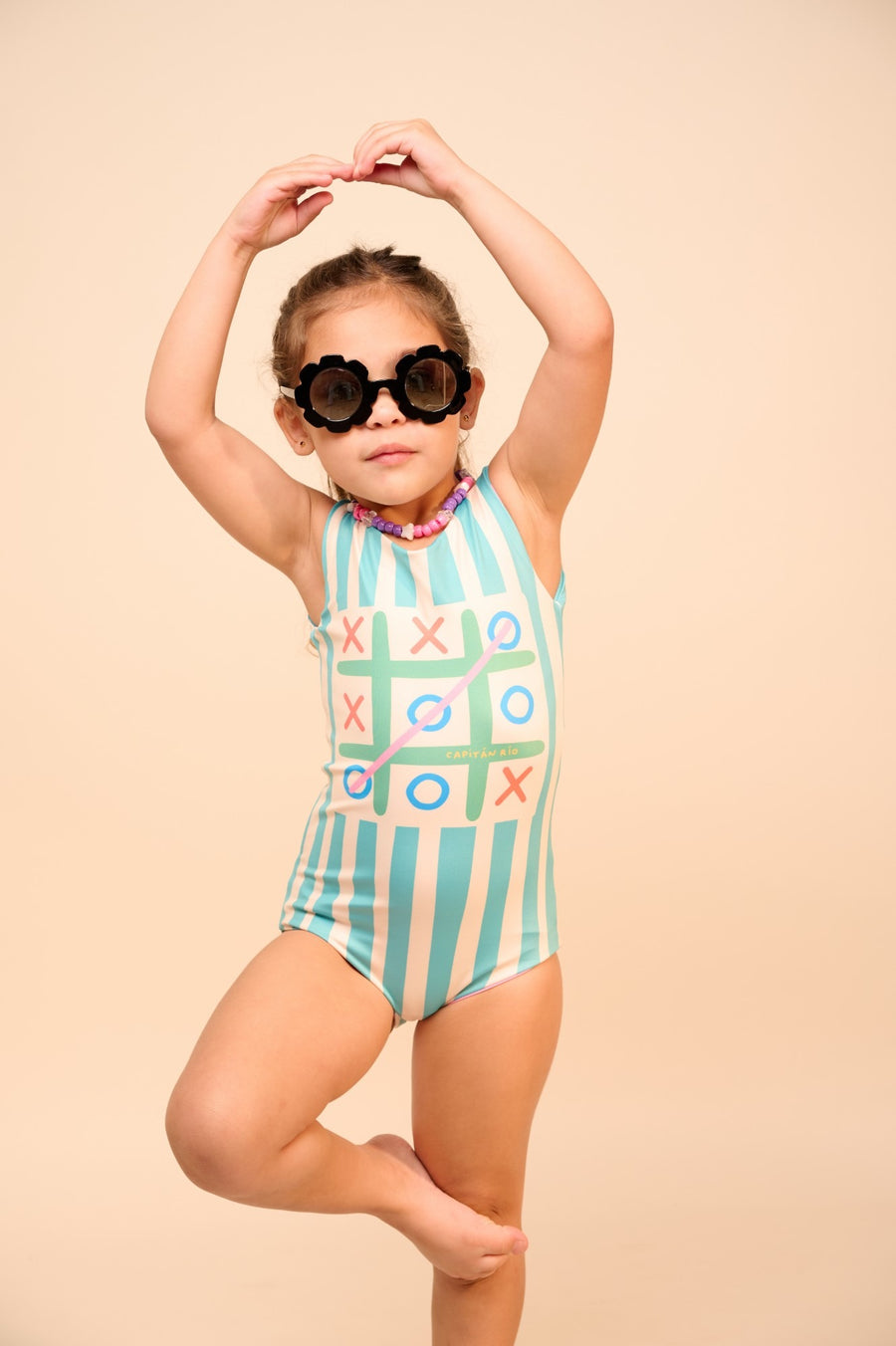 Niña con lentes de flor y traje de baño de tres en raya