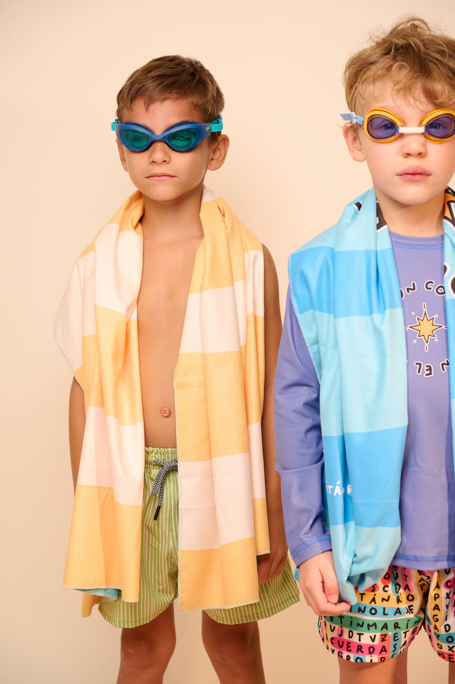 Dos niños con lentes de natación y toallas Capitán Río