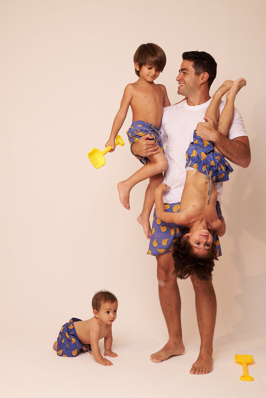 Papá jugando con sus tres hijos, todos con shorts a juego